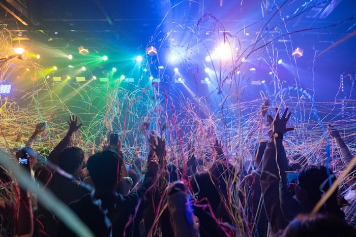 Crowd celebrating a festival with colorful confetti and lights