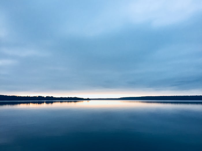 Peaceful sunset over a lake representing a calm Sunday evening blessing